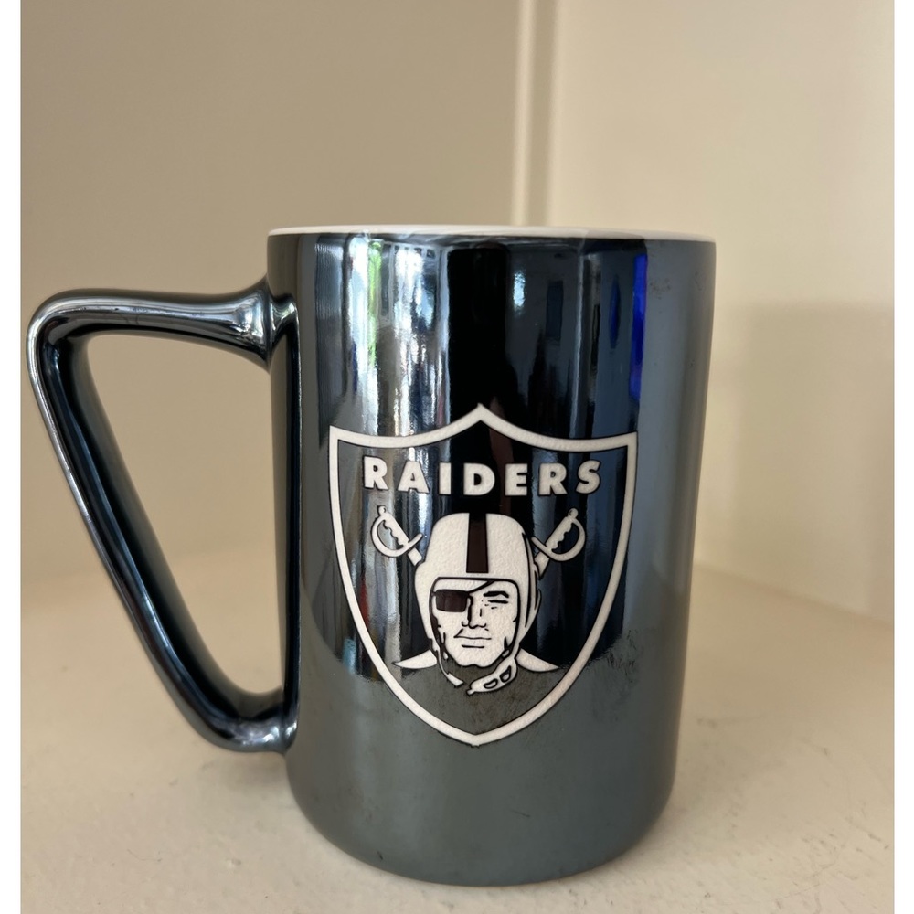 RAIDERS coffee mug in excellent pre owned by. Mug is an opalescent black